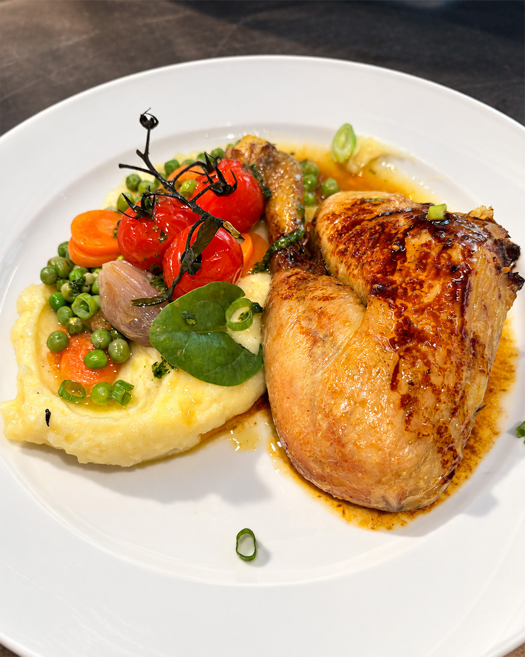 Volaille r&ocirc;tie servie avec pur&eacute;e, petits pois, carottes et tomates