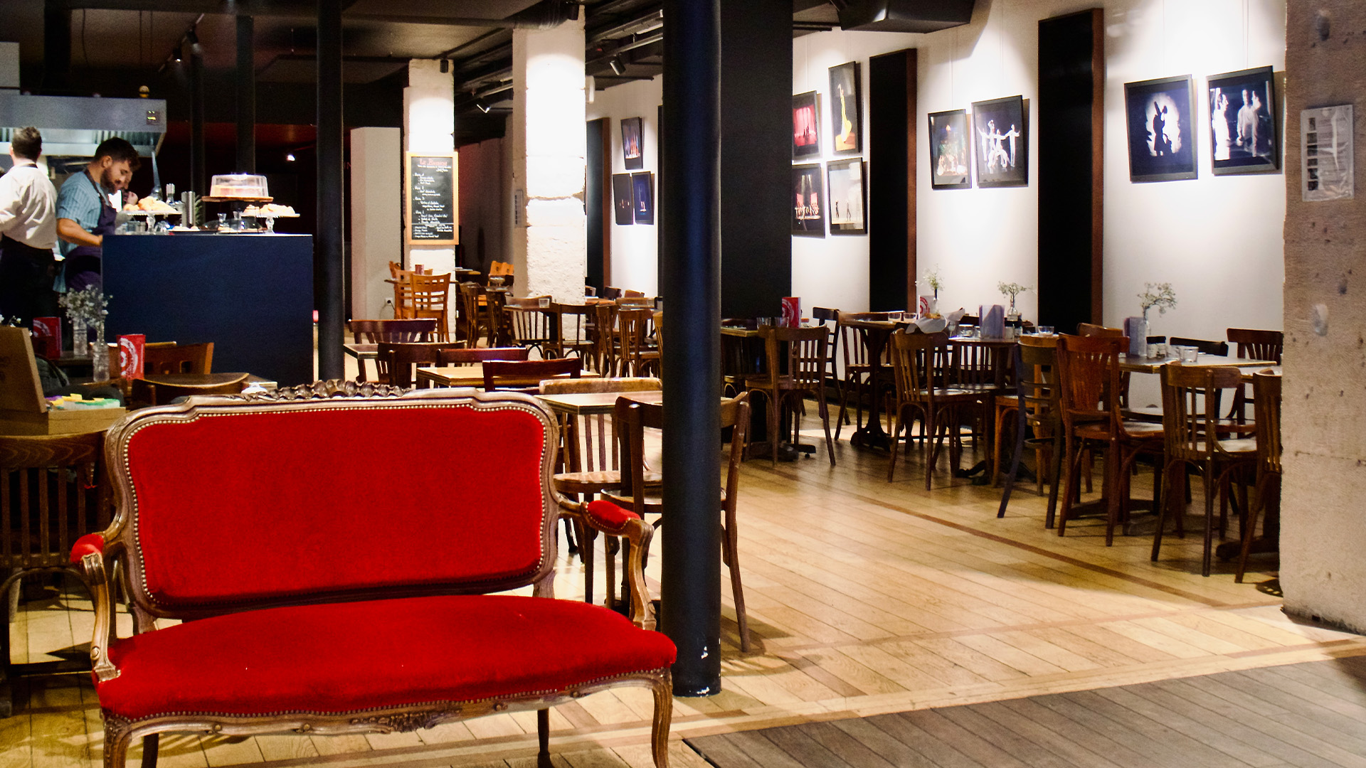 Salle du restaurant Sk&eacute;n&eacute; avec banquette rouge et photographies de spectacles