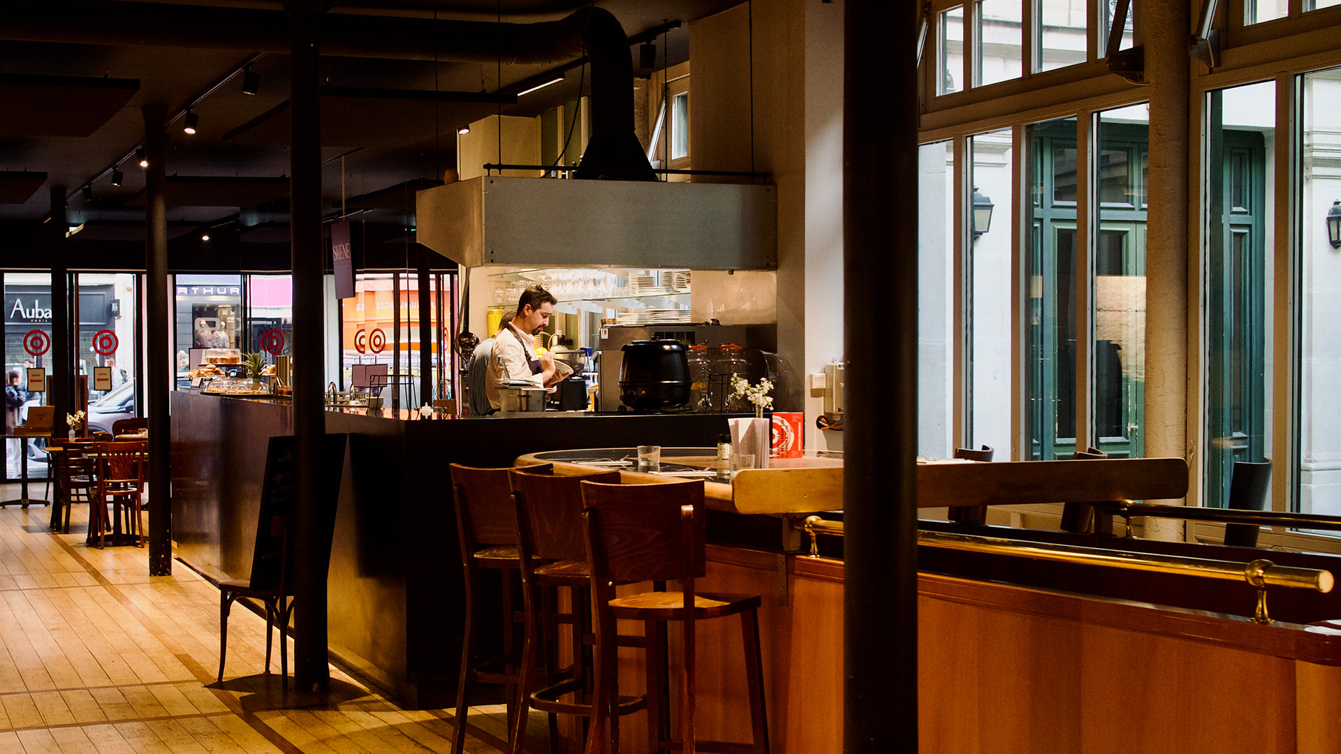 Vue int&eacute;rieure du restaurant Sk&eacute;n&eacute; avec comptoir, cuisine ouverte et grandes fen&ecirc;tres