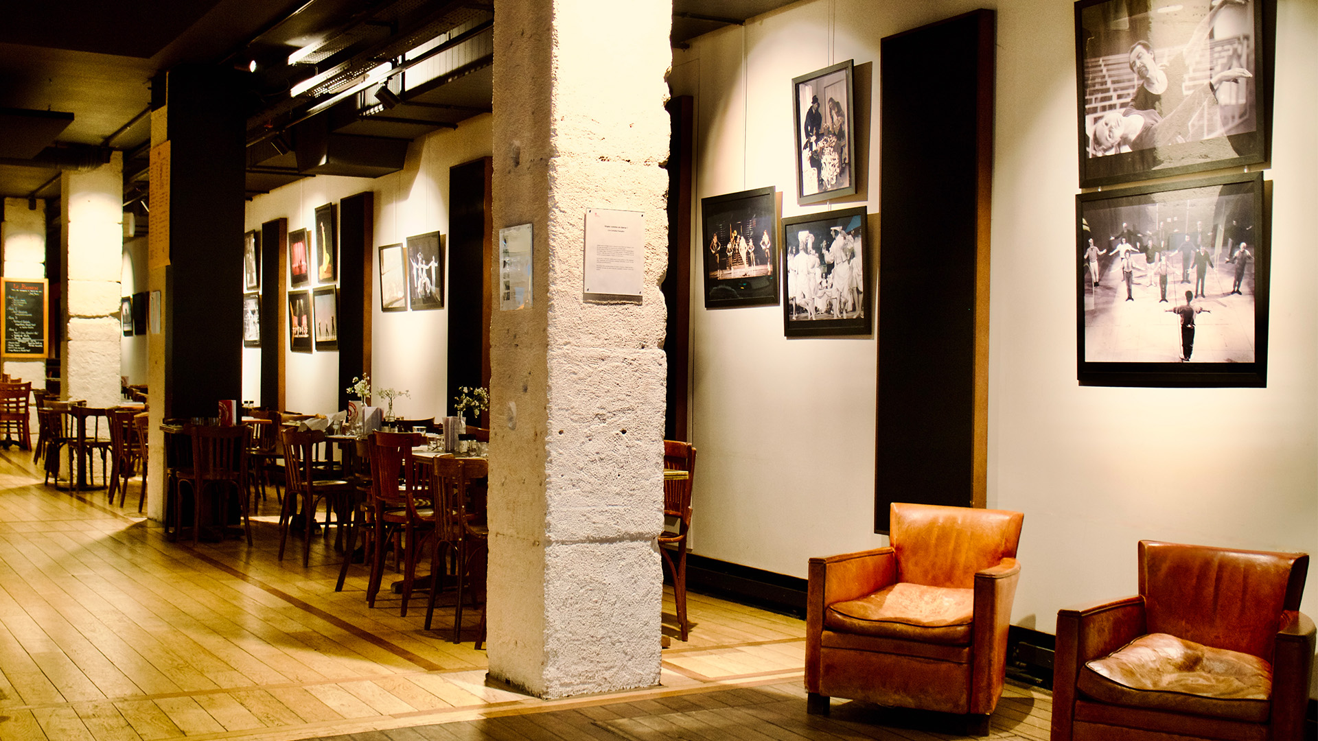 Salle du restaurant Sk&eacute;n&eacute; avec fauteuils en cuir et photographies de sc&egrave;ne au mur