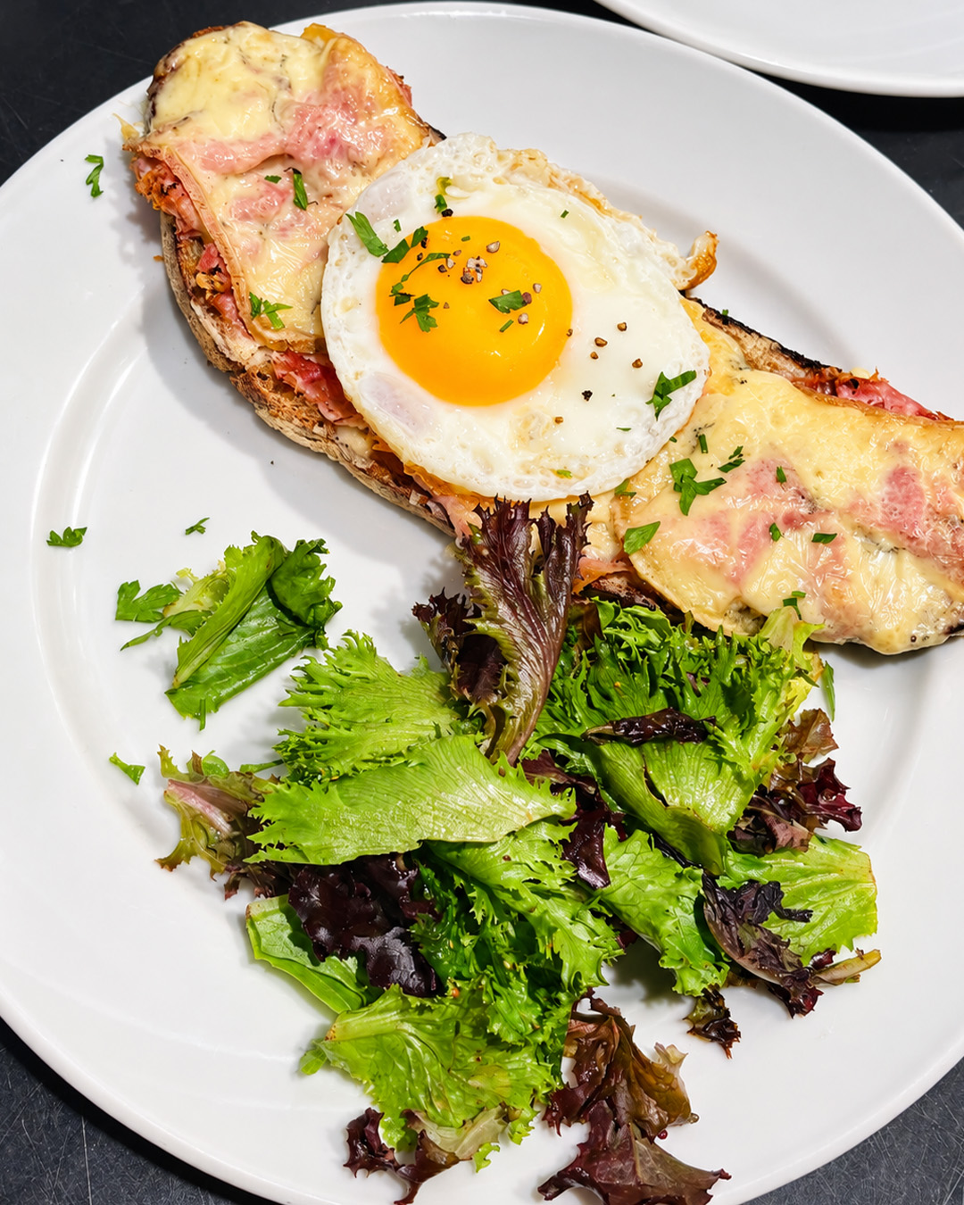 Tartine gratin&eacute;e &agrave; l'&oelig;uf accompagn&eacute;e d'une salade verte